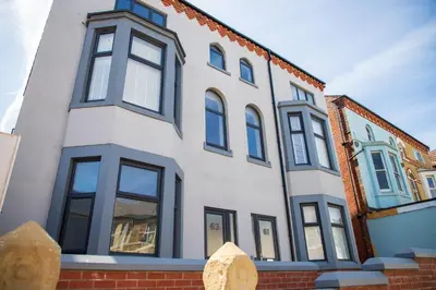 a white building with black windows on a street at Withnell Stays - Apartment Six in Blackpool