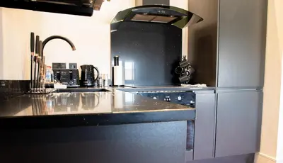a kitchen with a black counter top and a sink at Withnell Stays - Apartment Six in Blackpool