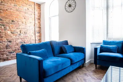 a blue couch and two blue chairs in a room at Withnell Stays - Apartment Five in Blackpool