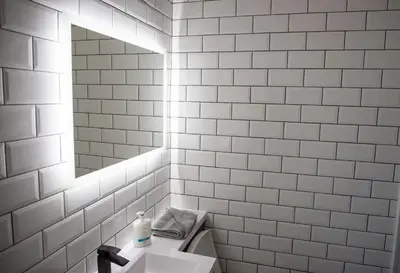 a white tiled bathroom with a sink and a mirror at Withnell Stays - Apartment Five in Blackpool