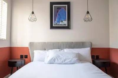 a bedroom with a white bed with two stools at Withnell Stays - Apartment Five in Blackpool