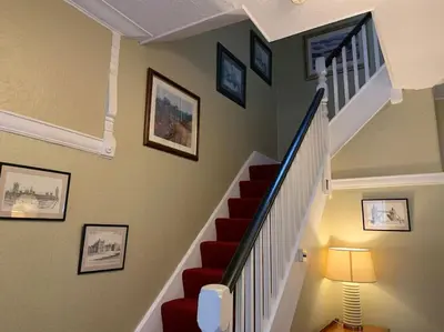 a staircase with a red couch and a lamp at Heather Glen. Six bedroom home near the sea. in Blackpool