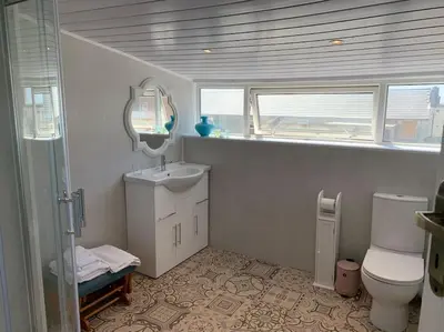 a bathroom with a sink and a toilet and a mirror at Heather Glen. Six bedroom home near the sea. in Blackpool