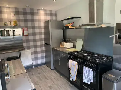 a kitchen with a stove and a counter top at Heather Glen. Six bedroom home near the sea. in Blackpool