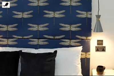 a bedroom with a bed with a blue butterfly wallpaper at Blackbird Accommodation and Luxury Apartments room 11 in Blackpool