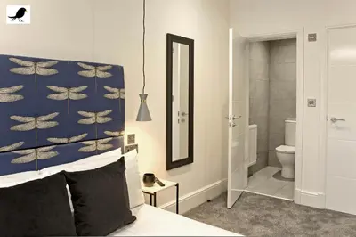 a bedroom with a bed and a bathroom with a mirror at Blackbird Accommodation and Luxury Apartments room 11 in Blackpool