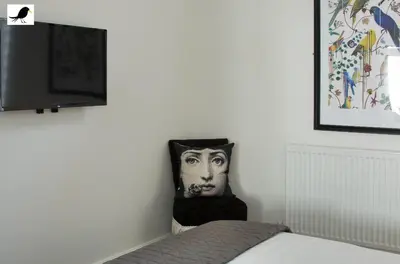 a bedroom with a bed and a tv and a picture of a man at Blackbird Accommodation and Luxury Apartments room 11 in Blackpool