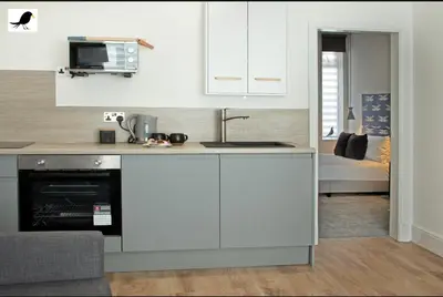 a kitchen with white cabinets and a stove top oven at Blackbird Accommodation and Luxury Apartments room 11 in Blackpool