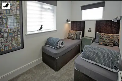 a bedroom with two beds and a bird on the window at Blackbird Accommodation and Luxury Apartments room 14 in Blackpool