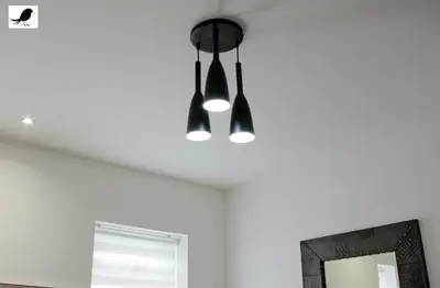 a black light hanging from a ceiling next to a mirror at Blackbird Accommodation and Luxury Apartments room 14 in Blackpool