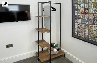 a shelf in the corner of a room with a tv at Blackbird Accommodation and Luxury Apartments room 14 in Blackpool