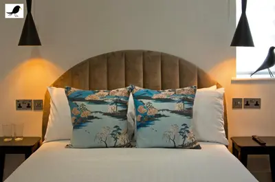 a bedroom with a large bed with blue and white pillows at Blackbird Accommodation and Luxury Apartments room 15 in Blackpool