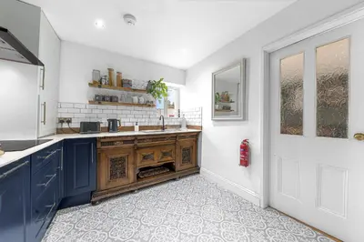 a kitchen with blue cabinets and a sink at No.1 The Coach House in Silverdale