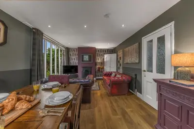 a kitchen and living room with a wooden table at No.1 The Coach House in Silverdale