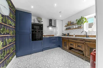 a kitchen with blue cabinets and a sink at No.1 The Coach House in Silverdale