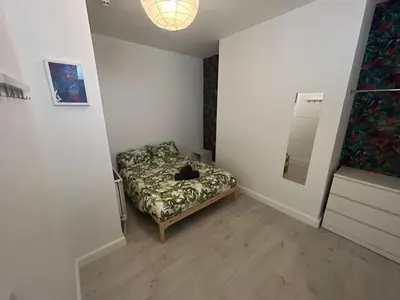 a room with a bed with a cat laying on it at Sunnyside Aparthotel Tropical suite, 10 min from Blackpool tower, outside space, free parking in Blackpool