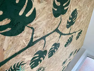 a painting of leaves on a wooden wall at Sunnyside Aparthotel Tropical suite, 10 min from Blackpool tower, outside space, free parking in Blackpool