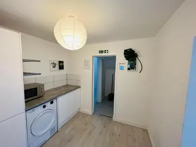 a kitchen with a washer and dryer and a light at Sunnyside Aparthotel Tropical suite, 10 min from Blackpool tower, outside space, free parking in Blackpool