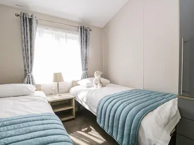 a bedroom with two beds with a teddy bear sitting on top at Parkers Place in Carnforth