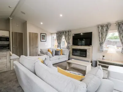 a living room with white couches and a tv at Parkers Place in Carnforth