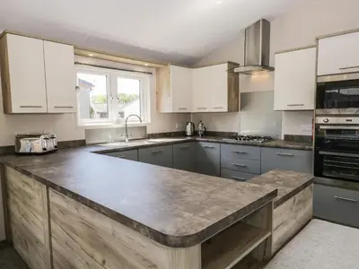 a kitchen with white cabinets and a large counter top at Parkers Place in Carnforth
