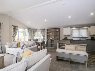 a living room with two couches and a kitchen at Parkers Place in Carnforth