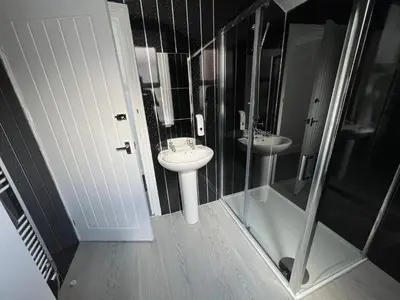 a black and white bathroom with a sink and a shower at Sunnyside Aparthotel Safari suite, Free Parking, 10Min Walk To Blackpool tower in Blackpool