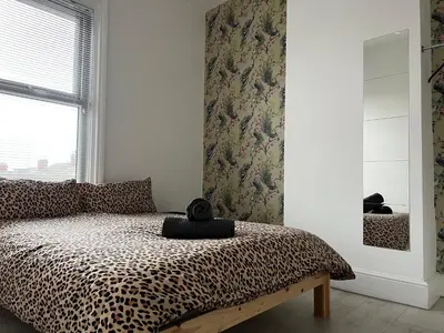 a bedroom with a leopard print bed and a window at Sunnyside Aparthotel Safari suite, Free Parking, 10Min Walk To Blackpool tower in Blackpool