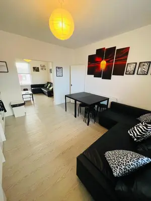 a living room with a black couch and a table at Sunnyside Aparthotel Safari suite, Free Parking, 10Min Walk To Blackpool tower in Blackpool