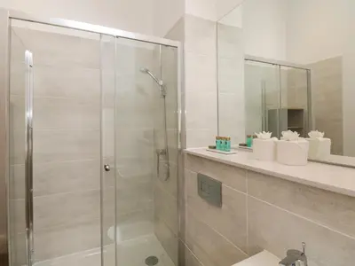 a bathroom with a shower with a glass door at Rowley House at Stone Cross Mansion in Ulverston