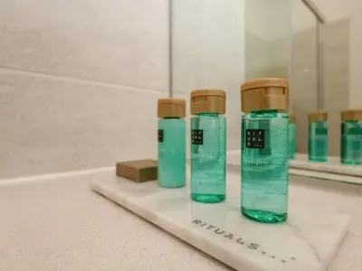 three green bottles sitting on a counter in a bathroom at Rowley House at Stone Cross Mansion in Ulverston