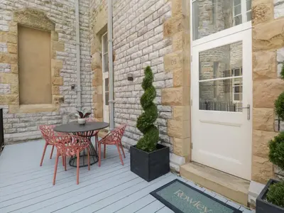 a patio with a table and chairs and a door at Rowley House at Stone Cross Mansion in Ulverston