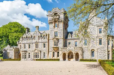 an old stone building with a tower on top at Rowley House at Stone Cross Mansion in Ulverston