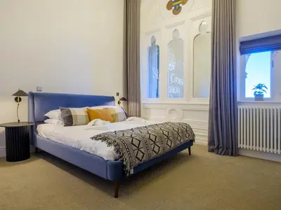 a blue bed in a room with a window at The Margaret Suite Stone Cross Mansion in Ulverston