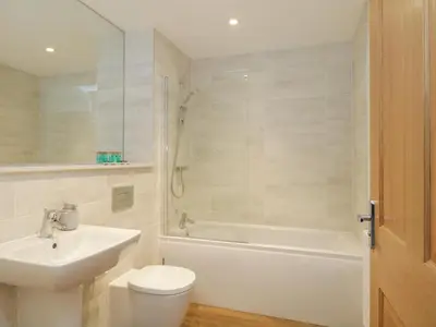 a bathroom with a sink and a toilet and a bath tub at The Margaret Suite Stone Cross Mansion in Ulverston