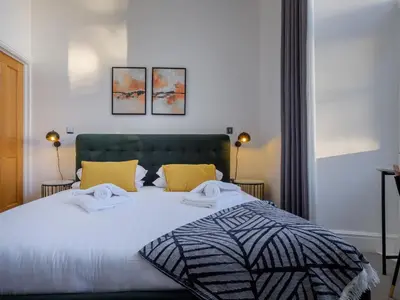 a bedroom with a bed with two towels on it at The Margaret Suite Stone Cross Mansion in Ulverston