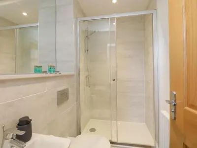 a bathroom with a shower with a toilet and a sink at The Margaret Suite Stone Cross Mansion in Ulverston