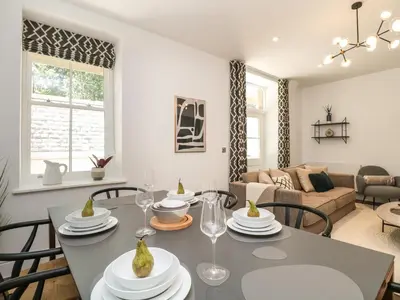 a dining room and living room with a table and chairs at Alice House Stone Cross Mansion in Ulverston