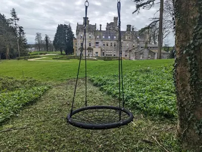 a tire swing in front of a castle at Alice House Stone Cross Mansion in Ulverston