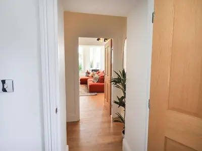 a hallway leading to a living room with a red couch at The Kathleen Suite Stone Cross Mansion in Ulverston