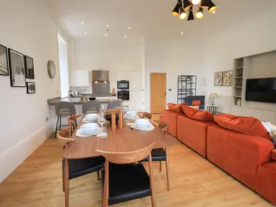 a living room with a table and a red couch at The Kathleen Suite Stone Cross Mansion in Ulverston