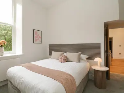 a bedroom with a bed with a teddy bear on it at The Florence Suite Stone Cross Mansion in Ulverston