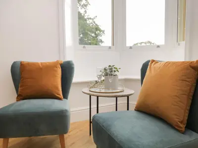 two chairs and a table in a room at The Florence Suite Stone Cross Mansion in Ulverston