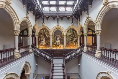a staircase in a building with a painting on the wall at The Florence Suite Stone Cross Mansion in Ulverston