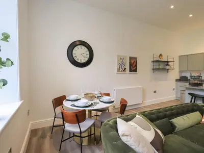 a living room with a green couch and a table at The Alfred Suite Stone Cross Mansion in Ulverston