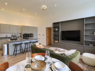 a living room and kitchen with a table and a couch at The Alfred Suite Stone Cross Mansion in Ulverston