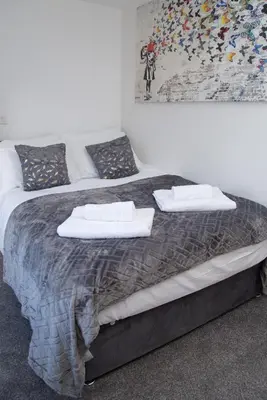 a large bed with two pillows on top of it at Hotel Rafay in Blackburn