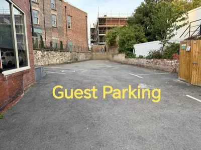 a parking lot with a sign that reads guest parking at Hotel Rafay in Blackburn
