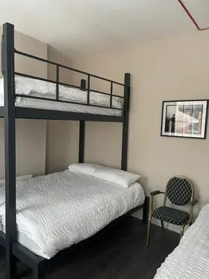 a bedroom with two bunk beds and a chair at 264 The Road End in Liverpool