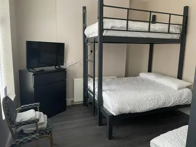 a bedroom with two bunk beds and a television at 264 The Road End in Liverpool